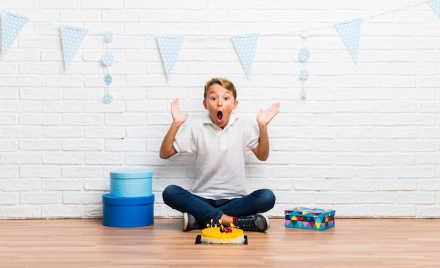 Jongen viert zijn verjaardag met een cake met verrassing en schokte gelaatsuitdrukking