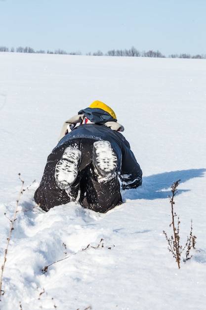 Jongen warm gekleed kruipend in de sneeuw