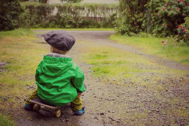 Foto jongen zit op een skateboard.