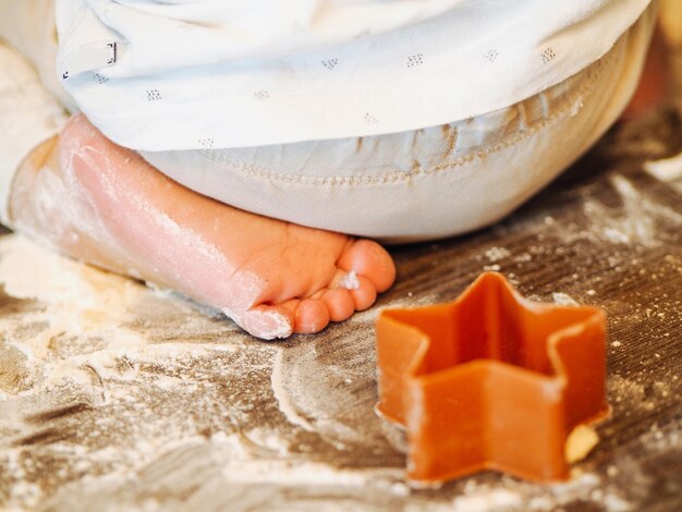 Jongen zit op een tafel met meel en koekjes