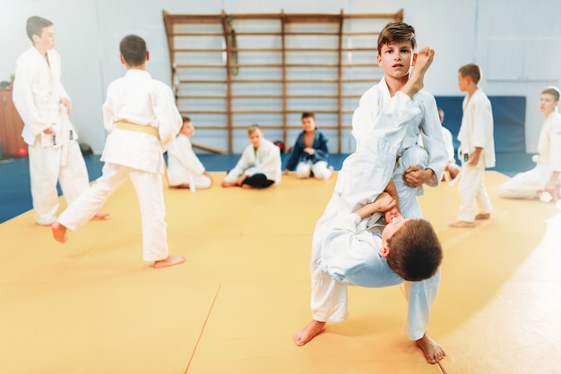 Jongens in kimonogevechten, judotraining voor kinderen. Jonge vechters in de sportschool, krijgskunst voor verdediging