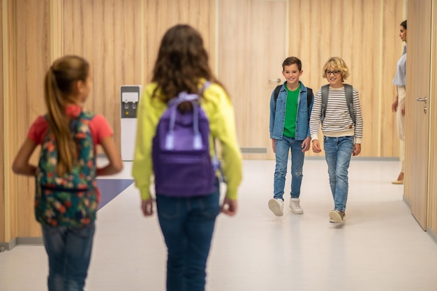 Jongens kijken naar meisjes die naar hen toe lopen