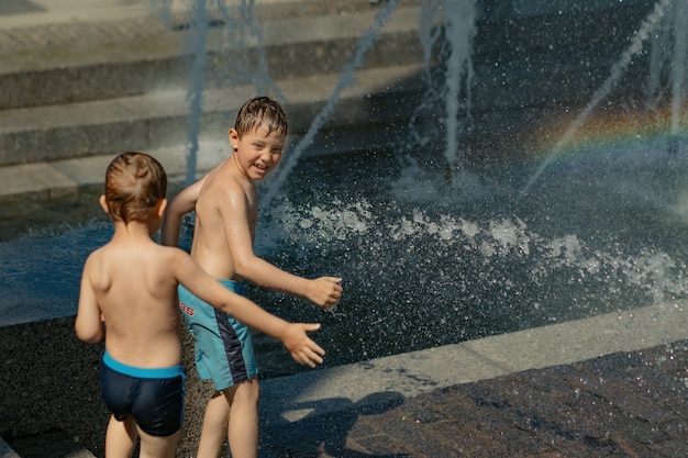 Jongens rennen en spelen in de stadsfontein op hete zomerdag sint-petersburg, rusland