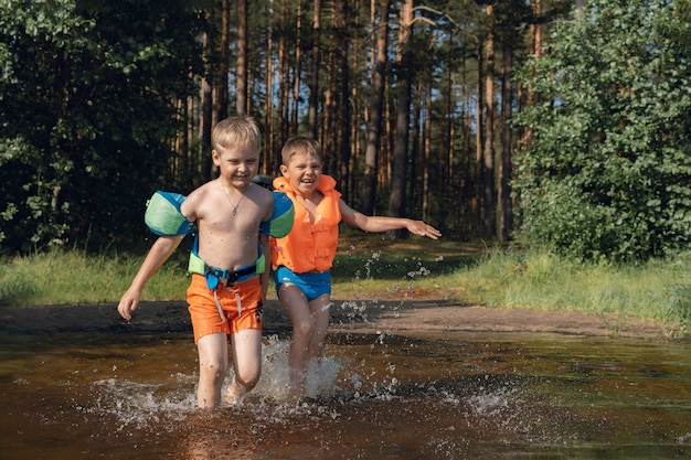 Jongens rennen in meer opspattend water