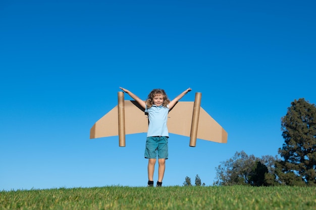 Jongenskind met vleugels in de lucht stelt zich een piloot voor en droomt van vliegende kinderen avontuur kinderen vrijheid en ...