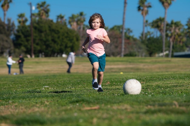 Jongenskind schopt voetbal op het sportveld tijdens voetbalwedstrijd kindervoetbal