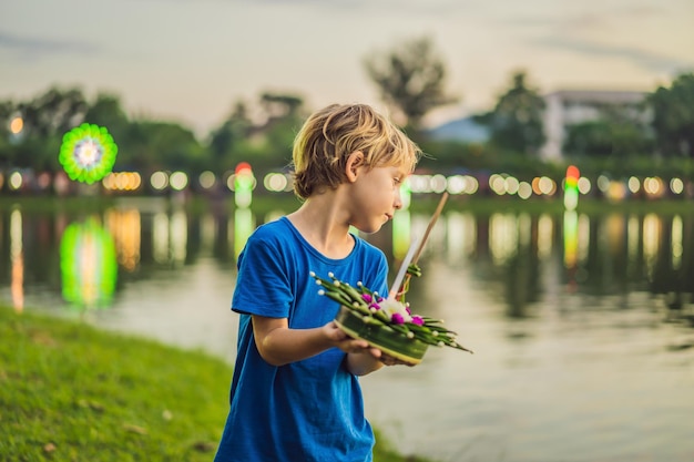 Jongenstoerist viert Loy Krathong Loopt op het water Loy Krathong-festival Mensen kopen bloemen en kaarsen om aan te steken en drijven op het water om het Loy Krathong-festival in Thailand te vieren