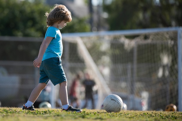 Jongensvoetballer die voetbal schopt op het sportveld Actieve kinderen Kindervoetbal Actieve balspellen