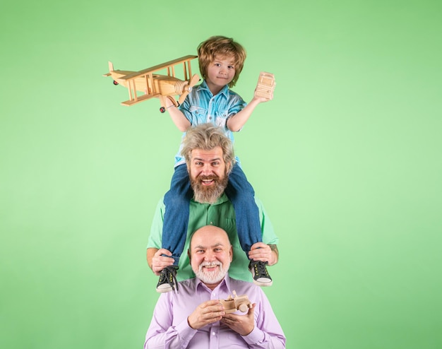 Jongenszoon met vader en grootvader met een stuk speelgoed vliegtuig spelen op geïsoleerde achtergrondfamilieavontuur