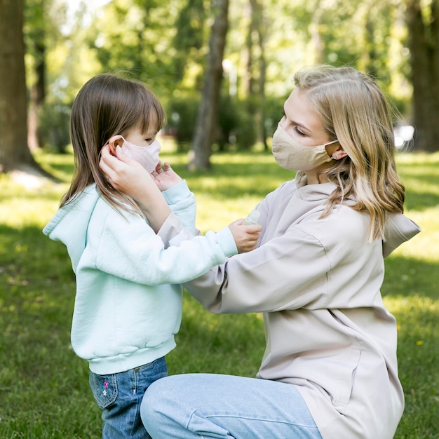 Jongere in openlucht en mamma die maskers dragen