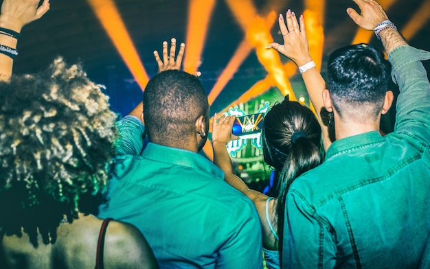 Jongeren dansen in nachtclub Handen omhoog op lasershow lichten in nachtclub afterparty