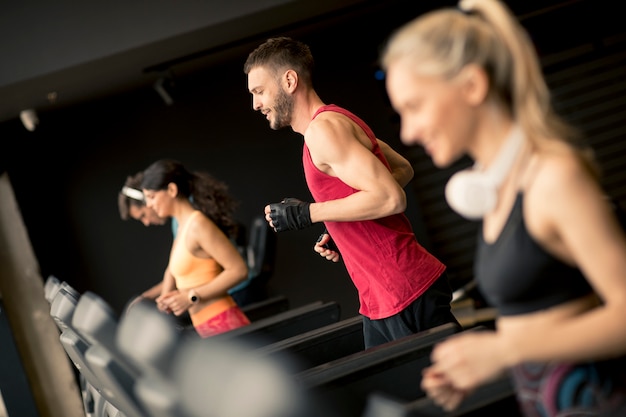 Jongeren die op tredmolens in moderne gymnastiek lopen