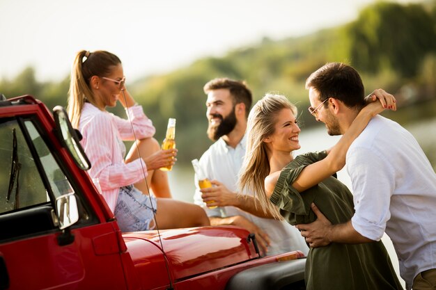 Jongeren die pret in convertibele auto hebben door rivier