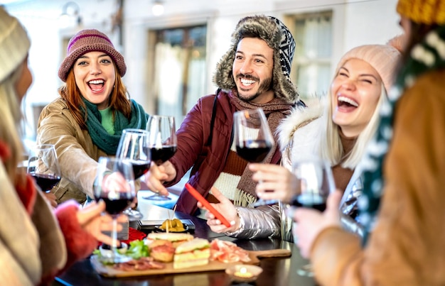 Jongeren die rode wijn roosteren bij restauranttuin