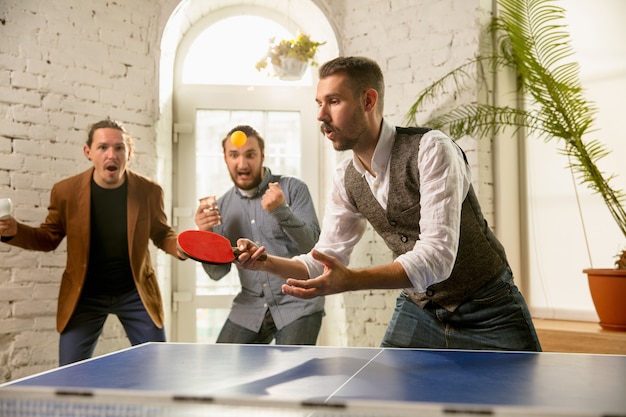 Jongeren die tafeltennis spelen op de werkplek, plezier hebben