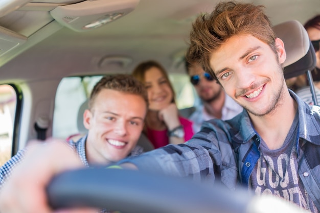 Jongeren die vakantie hebben die van plezier rijdende auto genieten