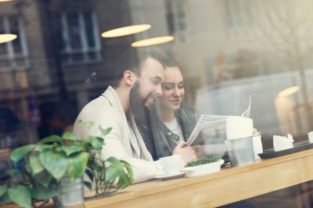 Jongeren in café kijken naar gids