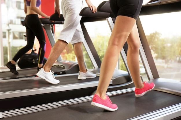 Foto jongeren lopen op loopbanden in de sportschool close-up