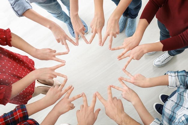 Jongeren maken een cirkel met hun handen als symbool van eenheid