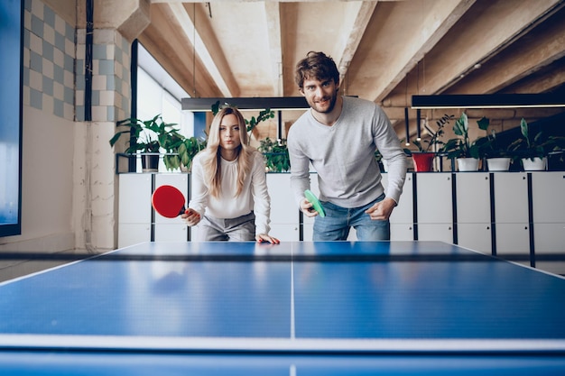 Jongeren, man en vrouw die tafeltennis spelen