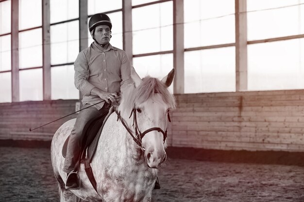 Jongeren op een paard trainen in een houten arena