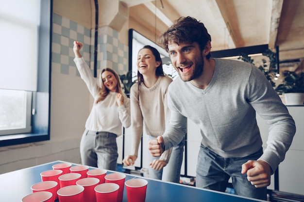 Jongerencollega's die bierpong spelen in modern bureau