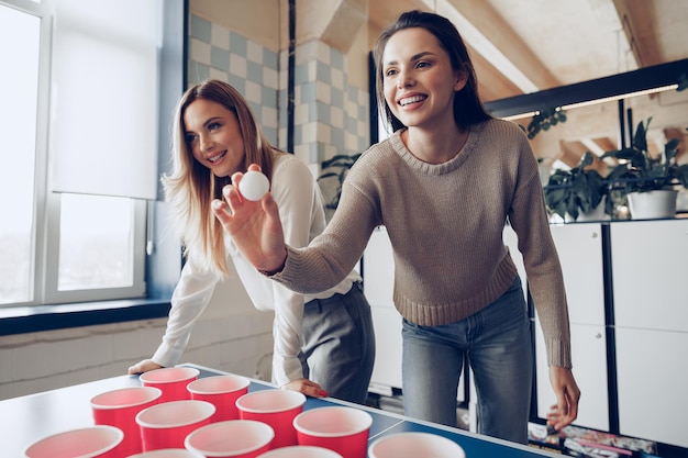 Jongerencollega's die bierpong spelen in modern bureau