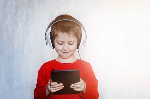 Jongetje met headset met behulp van touchpad, vroeg onderwijs en playng