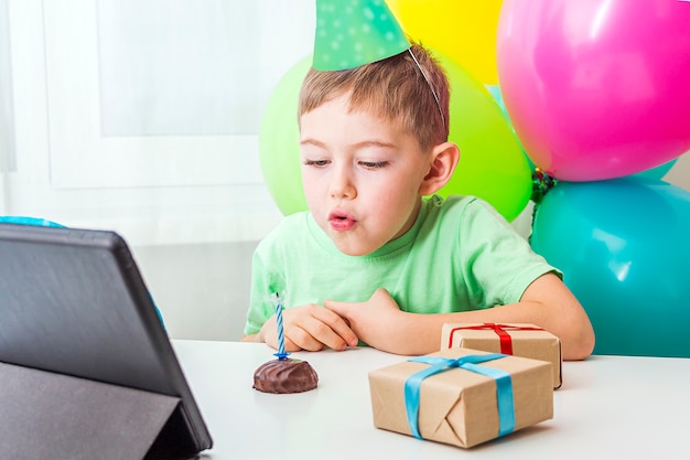 Jongetje viert verjaardag online met vriend of grootouders op videogesprek