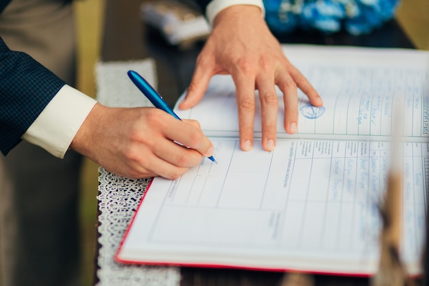 Jonggehuwden zetten hun handtekening bij het registreren van een huwelijk