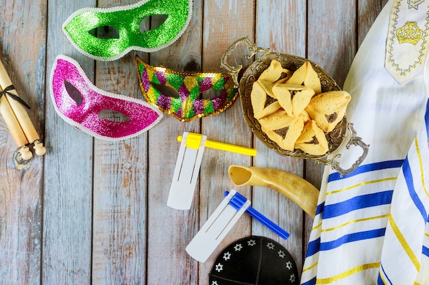 Foto joods carnaval purim-feest met hamantaschen-koekjes, lawaaimaker en masker met perkament