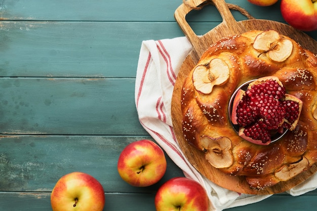 Joodse feestdagen Rosj Hasjana of Rosj Hasjana granaatappel appels honing en ronde challah op oude houten blauwe tafel achtergrond Joodse herfstviering Shana Tova Jom Kipoer concept bovenaanzicht