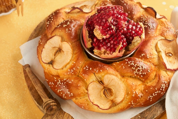 Foto joodse feestdagen rosj hasjana of rosj hasjana granaatappel appels honing en ronde challah op rustieke gele tabelachtergrond joodse herfstviering shana tova jom kipoer concept bovenaanzicht