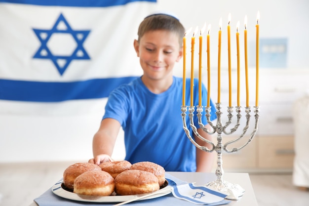 Joodse jongen met traditionele sufganiyah thuis