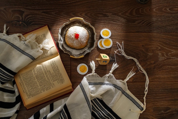 Joodse religieuze feestdag Chanoeka met vakantie Chanoeka traditionele kandelaar donut glas wijn tallit en religieuze boeken Tenach op een donkere achtergrond Bovenaanzicht