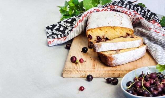 Jostaberry sponge cake on wooden cutting board. Copy space