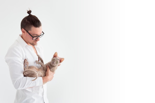 Joung man holding a cornish rex cat in his arms Banner