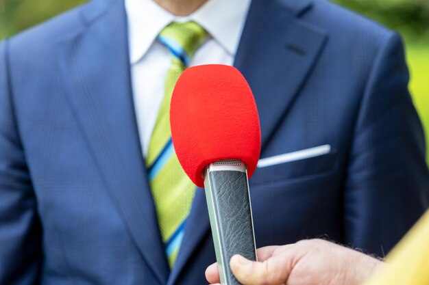 Foto journalist met een microfoon die een media-interview geeft met een politicus of zakenman