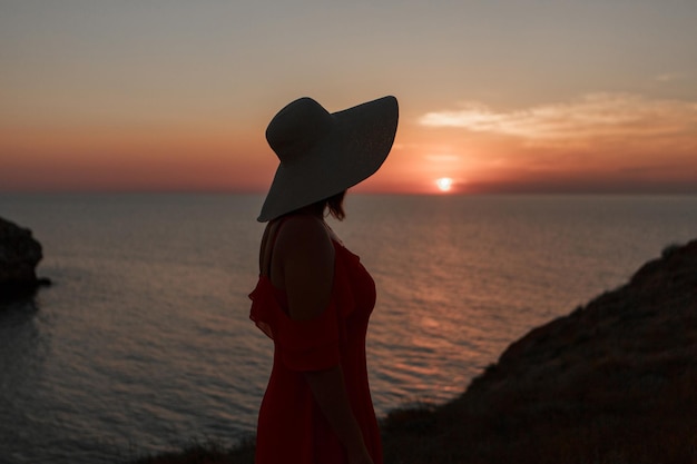 journey to the sea. a girl in a dress and hat is walking along the beach. a tourist walks along the sea coast. hot trips during the holiday period. copy space