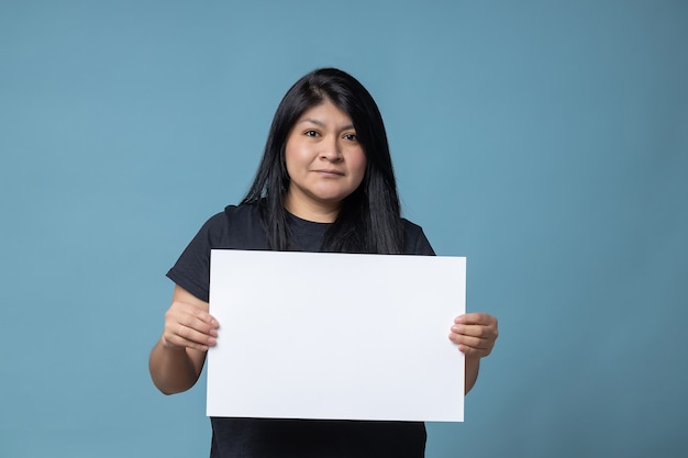 Jouw tekst hier. Mexicaanse Latijnse vrouw met leeg leeg bord. Studio portret met blauwe achtergrond.