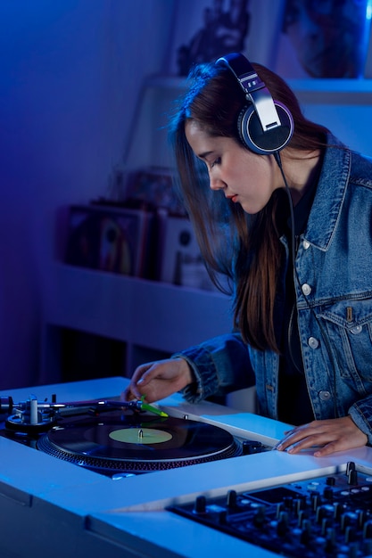 Photo joven mujer dj latina mezclando msica en una tienda de discos de vinilo