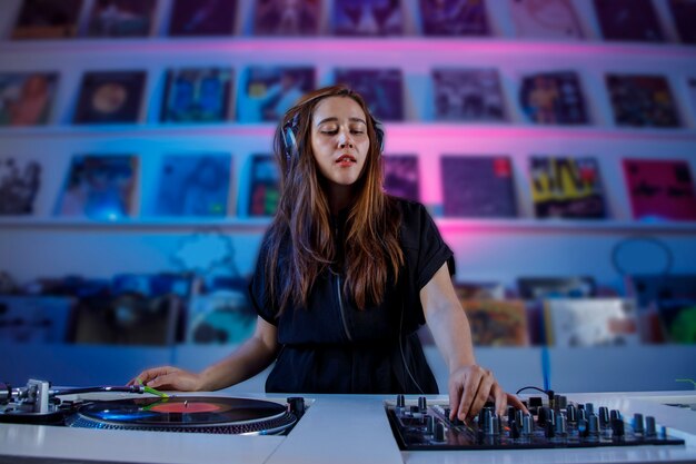 Joven mujer dj 라티 mezclando msica EN una tienda 드 discos 드 vinilo