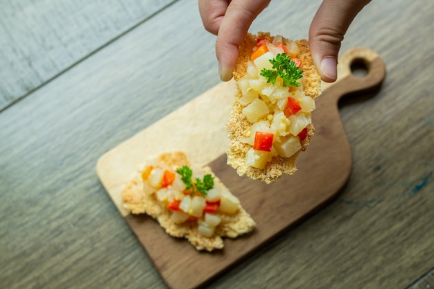 Joven sostiene casabe con antipasto de berenjena