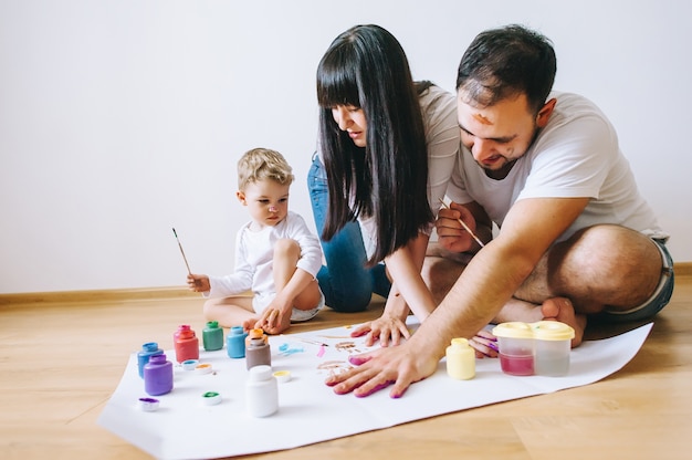 Joy family art happy father  mother and son show hands in bright colors paint together picture art