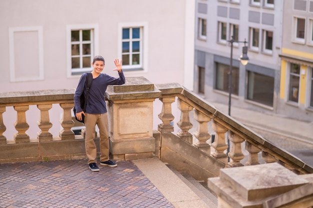 Joyful adolescent greeting someone on the terrace