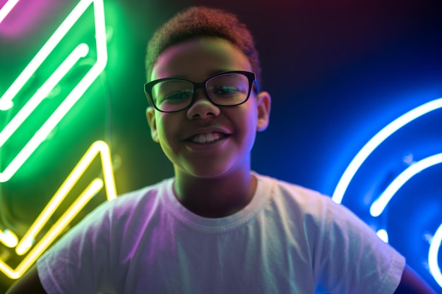 Joyful adolescent posing for the camera against neon signs