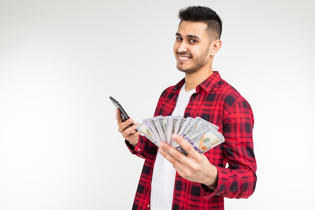 Joyful adorable brunette man won the lottery and received a cash prize on a white with copy space