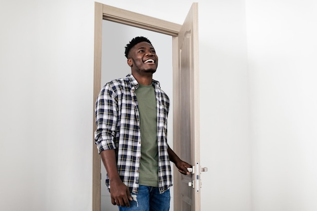 Joyful African American Male Opening Door Entering His New Apartment