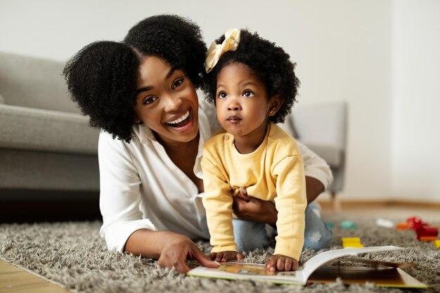 Joyful african american mother and daughter have fun at home