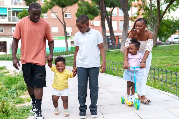 Joyful African Family Strolling Through Colorful City Park Hand in Hand